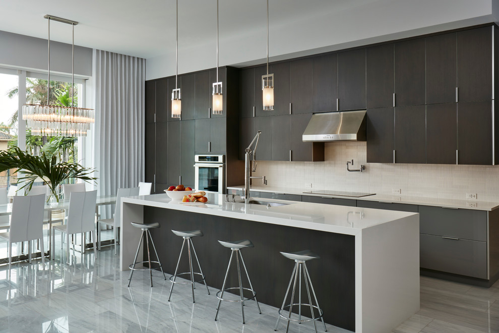 Contemporary kitchen/diner in Miami with a submerged sink, flat-panel cabinets, dark wood cabinets, beige splashback and an island.