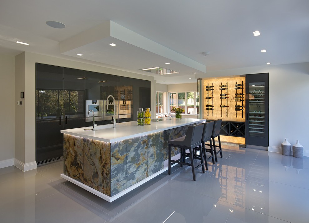 ハートフォードシャーにある高級な広いコンテンポラリースタイルのおしゃれなキッチン (一体型シンク、ガラス扉のキャビネット、グレーのキャビネット、人工大理石カウンター、磁器タイルの床) の写真