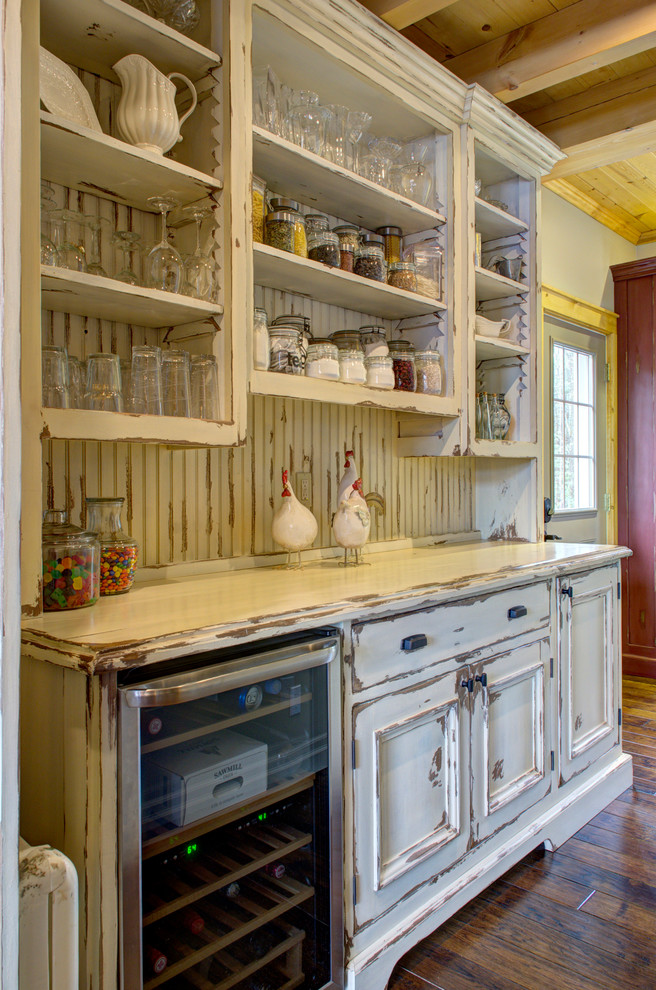 Photo of a small rustic galley kitchen pantry in Toronto with a submerged sink, recessed-panel cabinets, distressed cabinets, granite worktops, beige splashback, stainless steel appliances, dark hardwood flooring and an island.