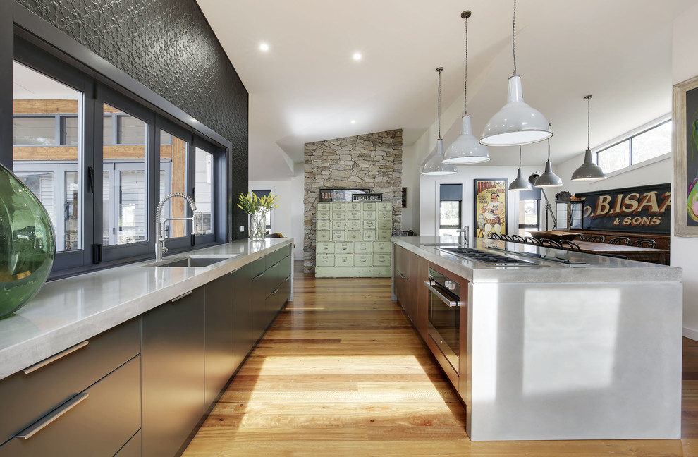 Eat-in kitchen - mid-sized contemporary medium tone wood floor eat-in kitchen idea in Sydney with an undermount sink, flat-panel cabinets, black cabinets, concrete countertops, stainless steel appliances and an island