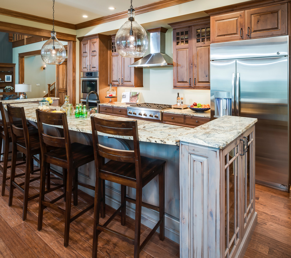 Inspiration for a timeless galley dark wood floor and brown floor open concept kitchen remodel in Other with an undermount sink, raised-panel cabinets, medium tone wood cabinets, granite countertops, stainless steel appliances and an island
