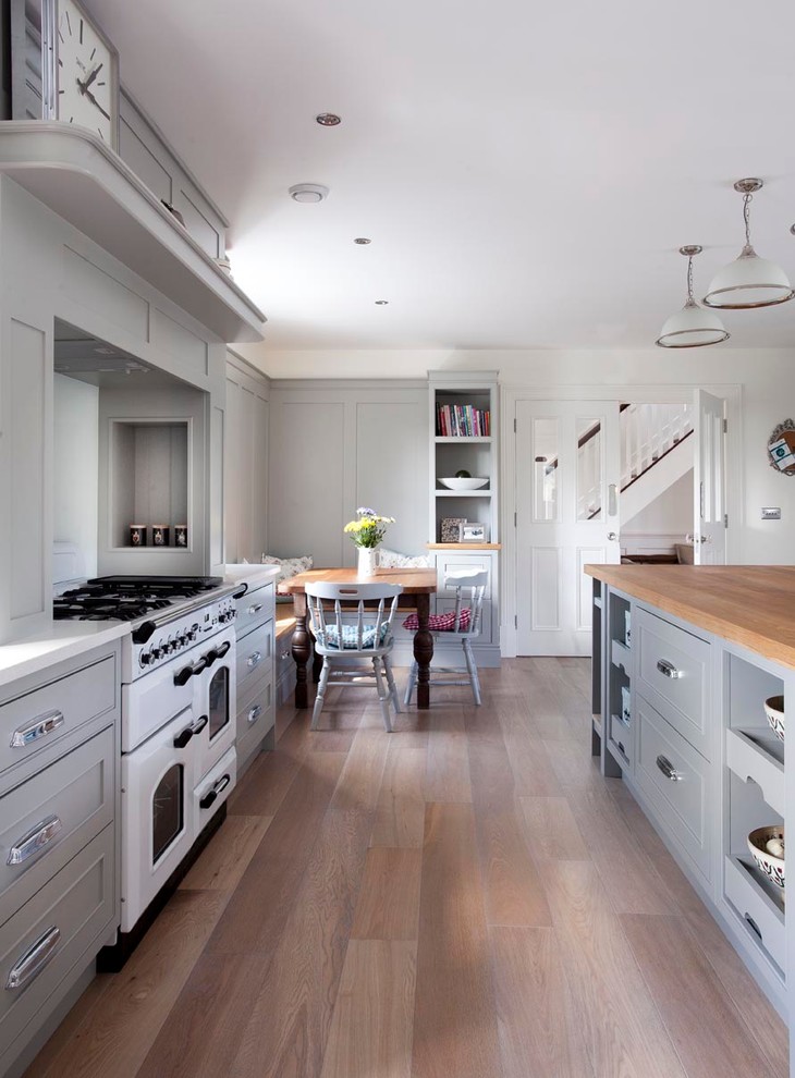 Zweizeilige Klassische Wohnküche mit Kassettenfronten, grauen Schränken, weißen Elektrogeräten, braunem Holzboden und Kücheninsel in Dublin