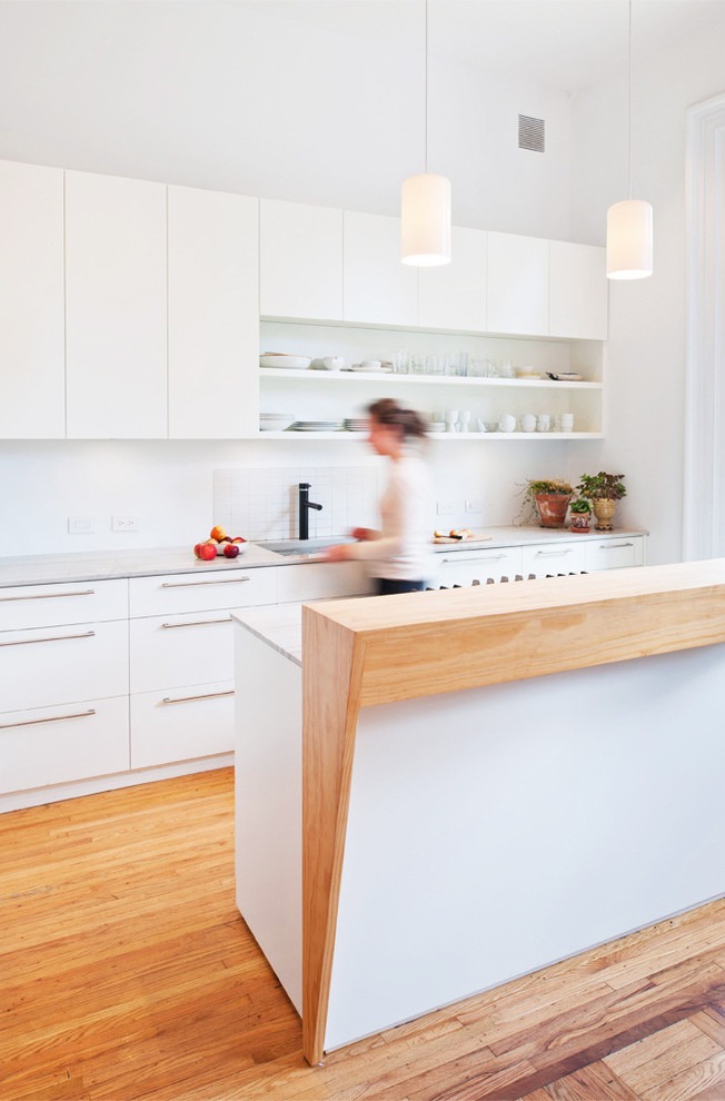 Idéer för funkis kök, med vita skåp, marmorbänkskiva, vitt stänkskydd, vita vitvaror, en undermonterad diskho, släta luckor, ljust trägolv och beiget golv