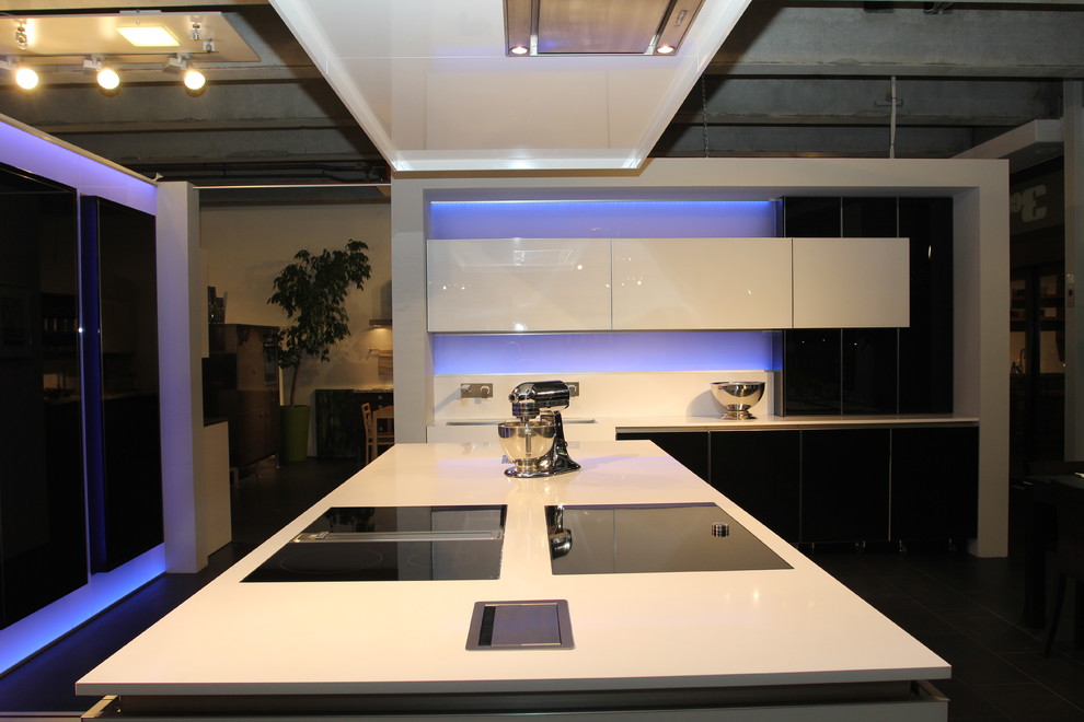Esempio di un'ampia cucina industriale con lavello sottopiano, ante di vetro, ante nere, top in quarzo composito, paraspruzzi con lastra di vetro, elettrodomestici in acciaio inossidabile, pavimento in linoleum e 2 o più isole