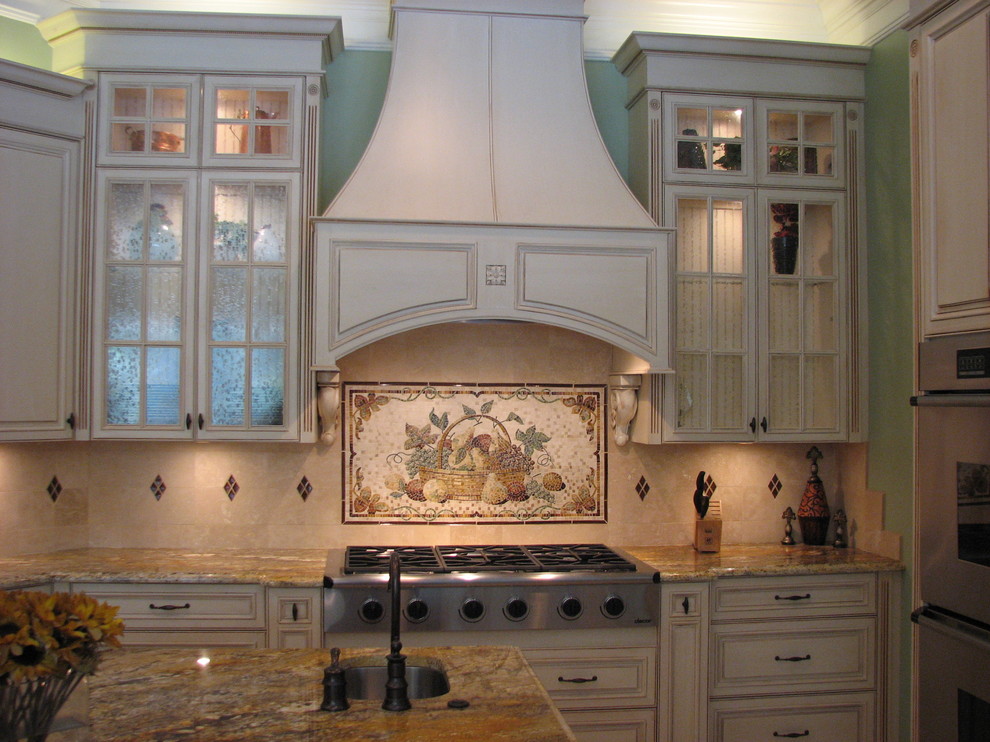 Inspiration för stora klassiska kök, med en undermonterad diskho, luckor med profilerade fronter, vita skåp, granitbänkskiva, beige stänkskydd, stänkskydd i stenkakel, rostfria vitvaror, travertin golv och en köksö