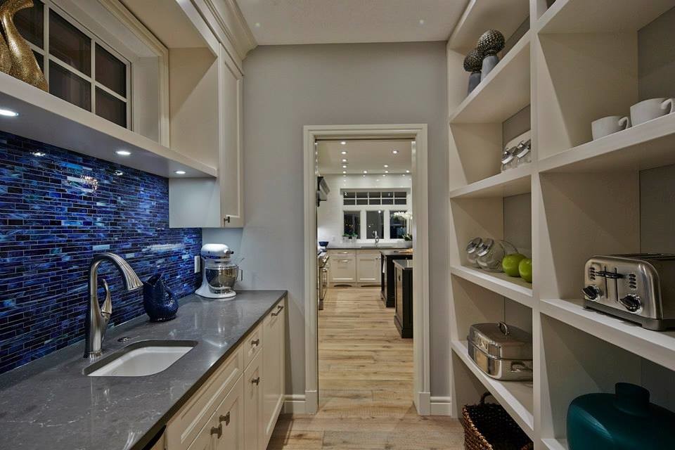 This is an example of a large traditional galley kitchen/diner in Other with a single-bowl sink, shaker cabinets, white cabinets, granite worktops, blue splashback, mosaic tiled splashback, stainless steel appliances, light hardwood flooring and multiple islands.
