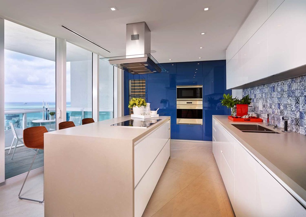 Moderne Küche mit Doppelwaschbecken, flächenbündigen Schrankfronten, weißen Schränken, bunter Rückwand, Küchengeräten aus Edelstahl und Kücheninsel in Miami