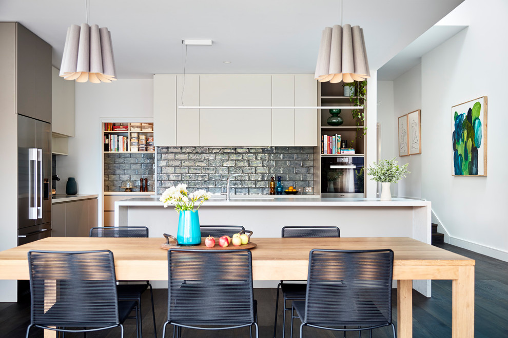 Inspiration for a large contemporary l-shaped kitchen in Melbourne with a submerged sink, flat-panel cabinets, grey splashback, stainless steel appliances, multiple islands, brown floors and white worktops.