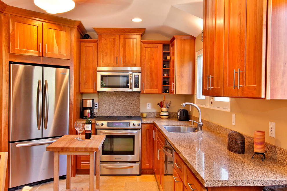 Klassische Küche mit Doppelwaschbecken, Schrankfronten im Shaker-Stil, hellbraunen Holzschränken, Küchenrückwand in Beige, Rückwand aus Stein und Küchengeräten aus Edelstahl in San Diego