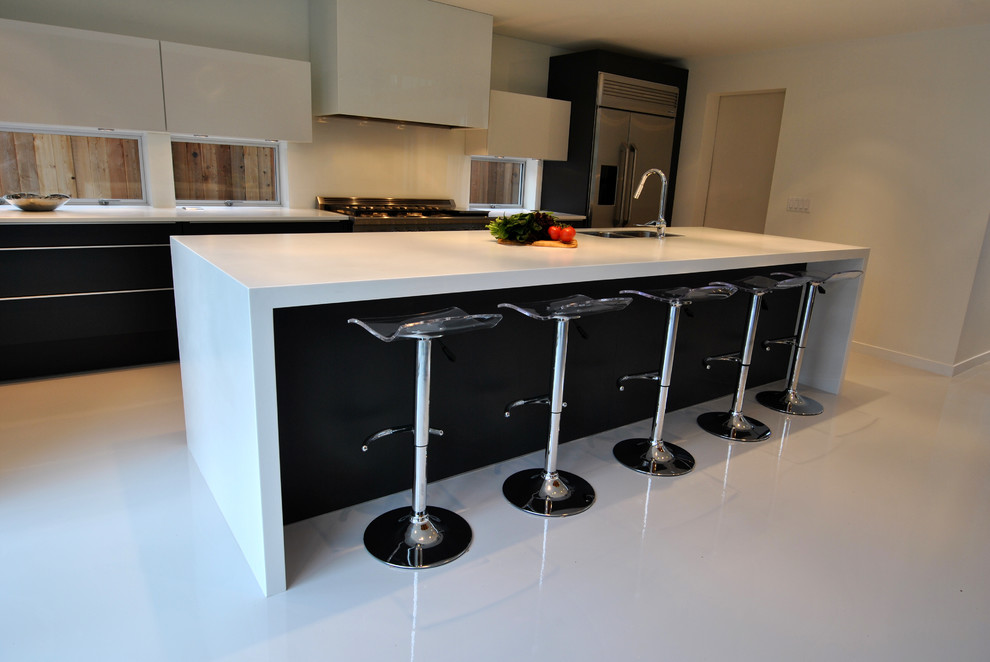 This is an example of a large contemporary kitchen/diner in Vancouver with a submerged sink, flat-panel cabinets, white cabinets, composite countertops, white splashback and stainless steel appliances.