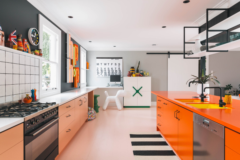 Inredning av ett modernt orange oranget kök, med en undermonterad diskho, laminatbänkskiva, vitt stänkskydd, stänkskydd i keramik, svarta vitvaror, målat trägolv, en köksö och rosa golv