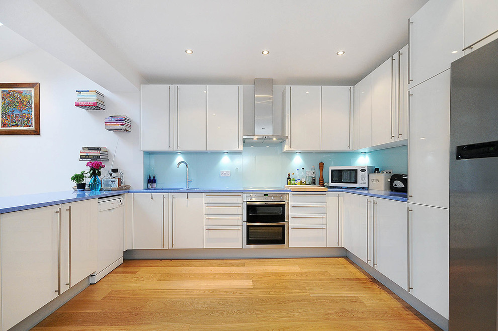 Large modern single-wall kitchen/diner in London with a single-bowl sink, open cabinets, blue cabinets, quartz worktops, blue splashback, glass tiled splashback, coloured appliances, slate flooring and an island.