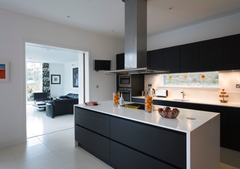 Einzeilige, Mittelgroße Moderne Wohnküche mit flächenbündigen Schrankfronten, dunklen Holzschränken, Quarzwerkstein-Arbeitsplatte, Küchengeräten aus Edelstahl, Porzellan-Bodenfliesen und Kücheninsel in Edinburgh