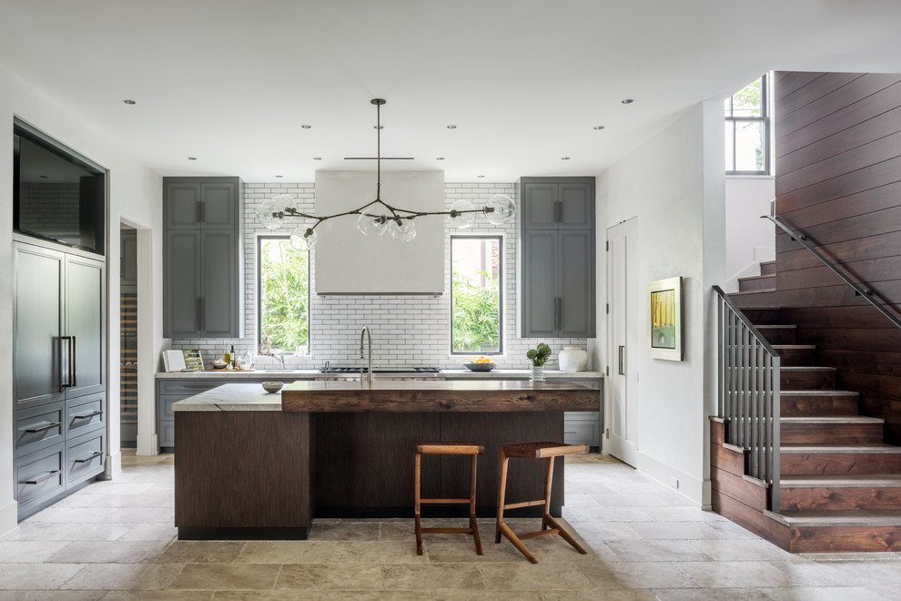 Einzeilige Moderne Küche mit Schrankfronten mit vertiefter Füllung, grauen Schränken, Küchenrückwand in Weiß, Rückwand aus Metrofliesen, Kücheninsel und Mauersteinen in Houston