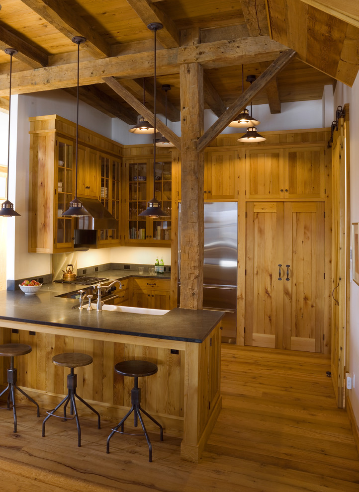 Foto på ett rustikt kök, med en rustik diskho, skåp i mellenmörkt trä, rostfria vitvaror och skåp i shakerstil