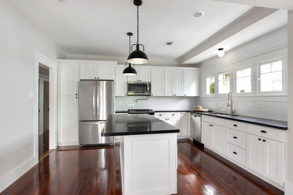 Inspiration for a mid-sized craftsman l-shaped dark wood floor eat-in kitchen remodel in New Orleans with an undermount sink, shaker cabinets, white cabinets, quartzite countertops, white backsplash, subway tile backsplash, stainless steel appliances and an island