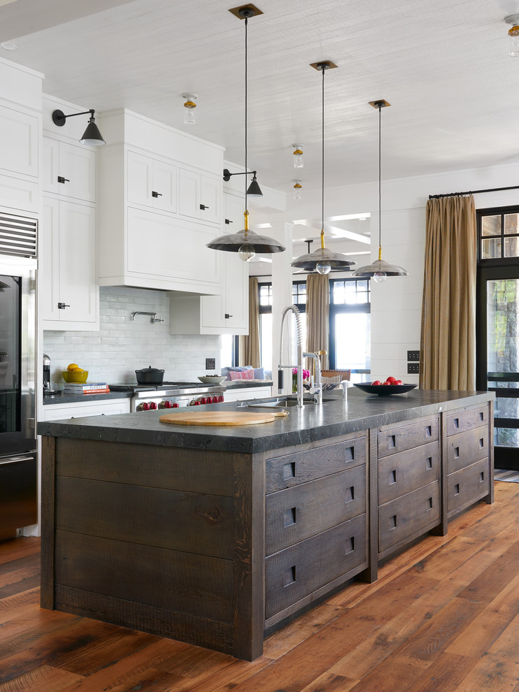Beach style medium tone wood floor and orange floor kitchen photo in Toronto with an undermount sink, shaker cabinets, white cabinets, white backsplash, subway tile backsplash, stainless steel appliances and an island
