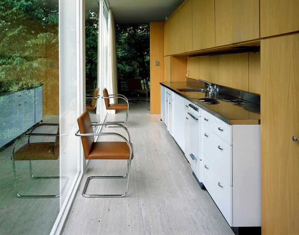 Idées déco pour une cuisine linéaire moderne en bois brun fermée avec un placard à porte plane et un électroménager blanc.