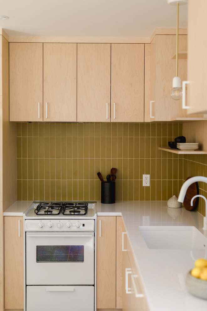 Foto på ett avskilt, litet skandinaviskt vit l-kök, med beige skåp, gult stänkskydd, stänkskydd i keramik, vita vitvaror, betonggolv och flerfärgat golv