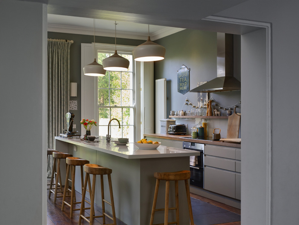 Design ideas for a classic galley kitchen in London with flat-panel cabinets and an island.