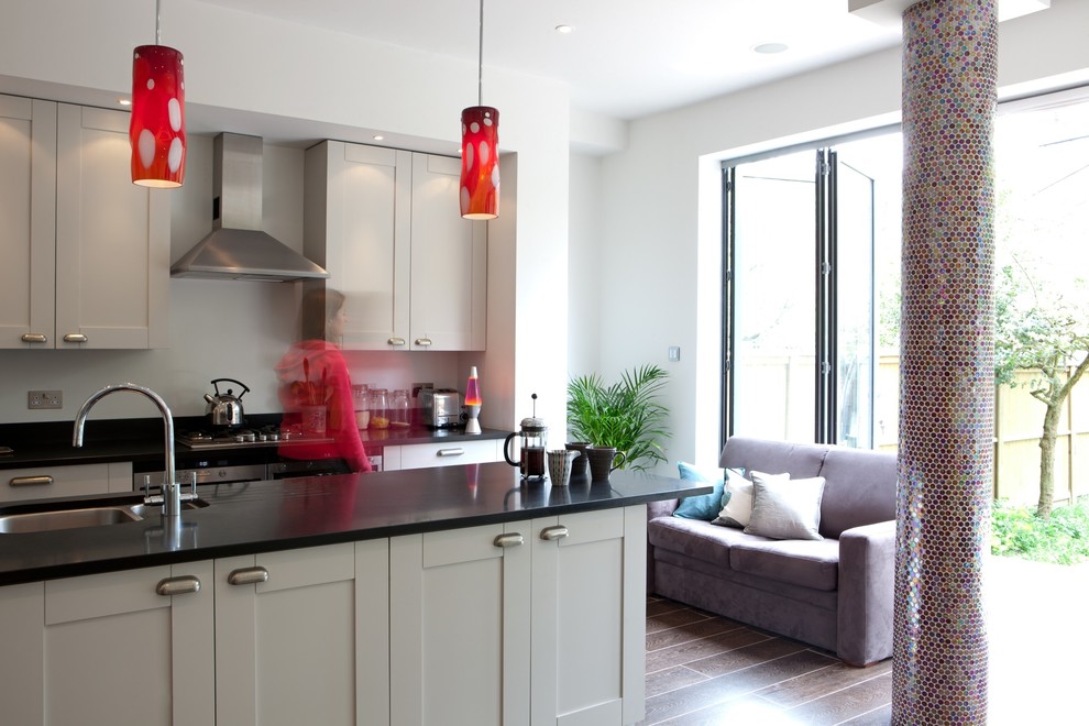 Inspiration for a mid-sized contemporary single-wall porcelain tile open concept kitchen remodel in London with shaker cabinets, gray cabinets, stainless steel appliances, an undermount sink, granite countertops, an island and gray backsplash