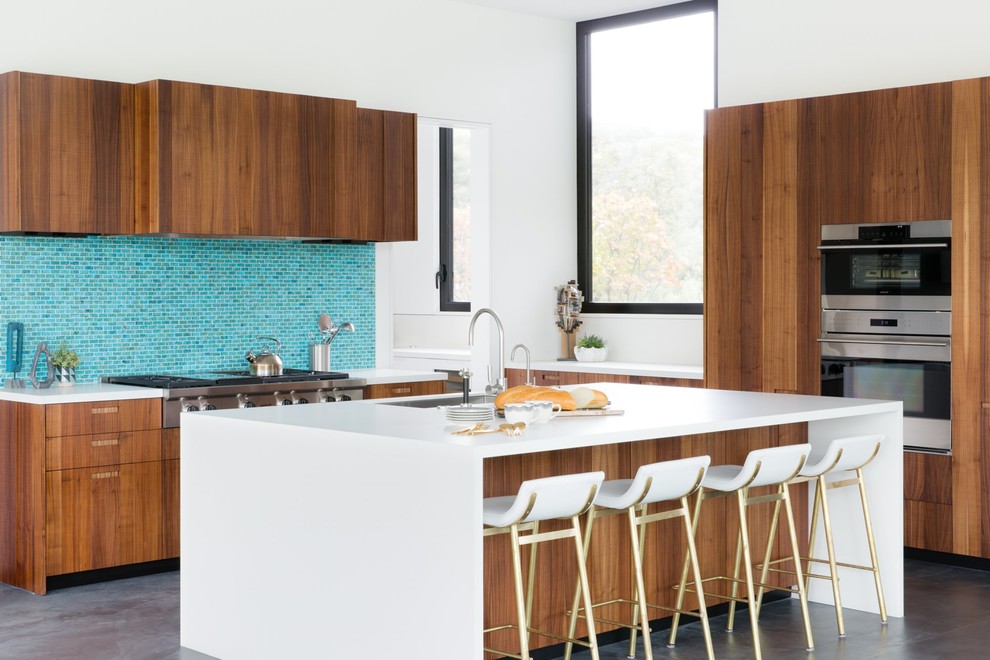 Trendy l-shaped concrete floor and gray floor kitchen photo in Other with an undermount sink, flat-panel cabinets, medium tone wood cabinets, blue backsplash, mosaic tile backsplash and an island