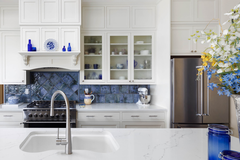 This is an example of a large classic galley open plan kitchen in Seattle with a submerged sink, shaker cabinets, blue cabinets, engineered stone countertops, blue splashback, ceramic splashback, stainless steel appliances, porcelain flooring, an island, brown floors and white worktops.