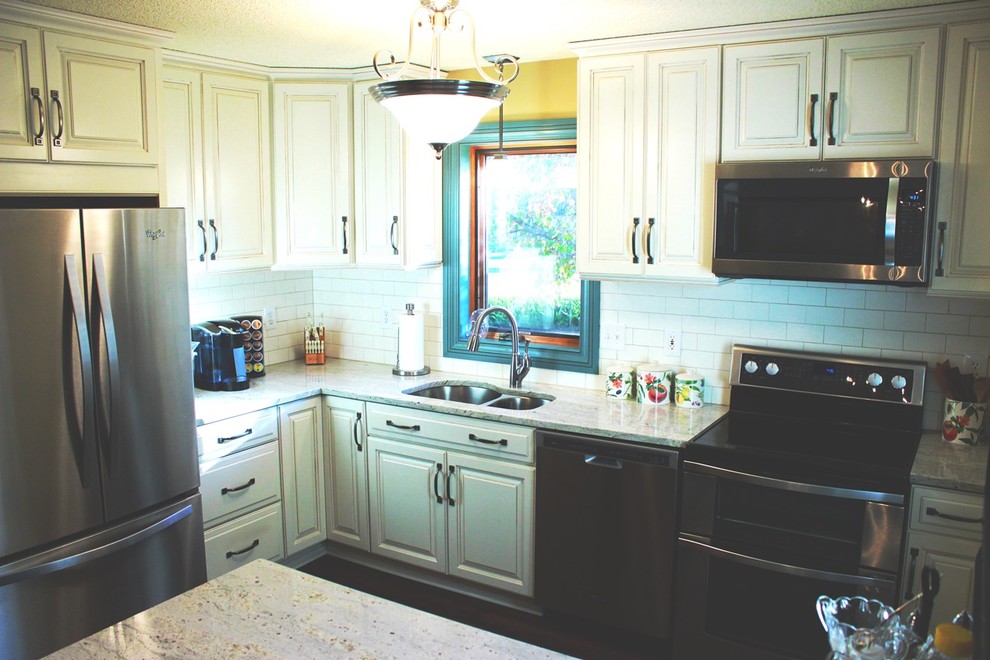 Example of a small transitional l-shaped dark wood floor eat-in kitchen design in Other with an undermount sink, raised-panel cabinets, white cabinets, granite countertops, white backsplash, porcelain backsplash, stainless steel appliances and a peninsula