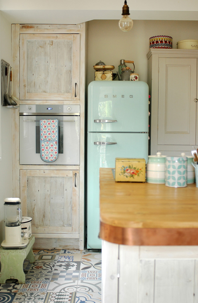 Scandi kitchen in Other with shaker cabinets, light wood cabinets, coloured appliances and an island.