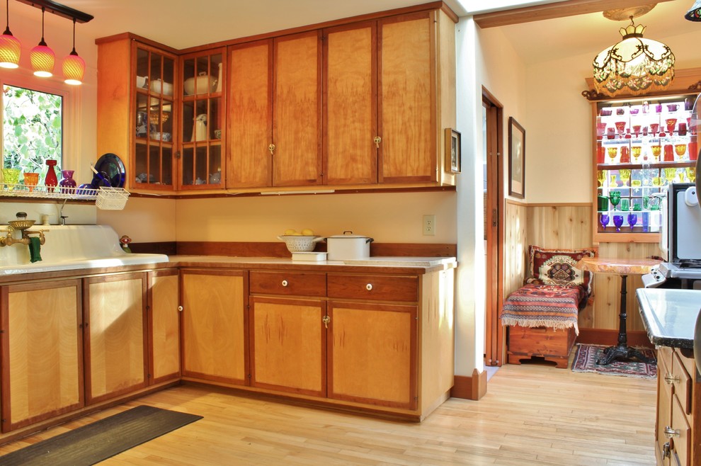 Example of an eclectic eat-in kitchen design in Seattle with a drop-in sink, flat-panel cabinets and medium tone wood cabinets