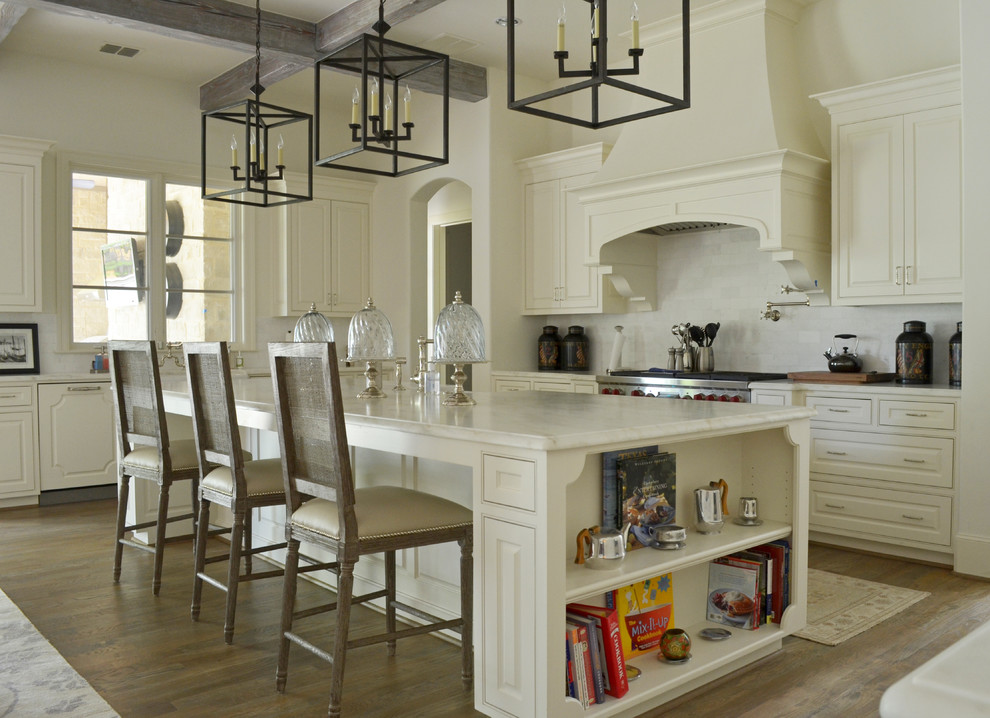 Tuscan l-shaped medium tone wood floor kitchen photo in Dallas with beaded inset cabinets, white cabinets, white backsplash, stainless steel appliances and an island