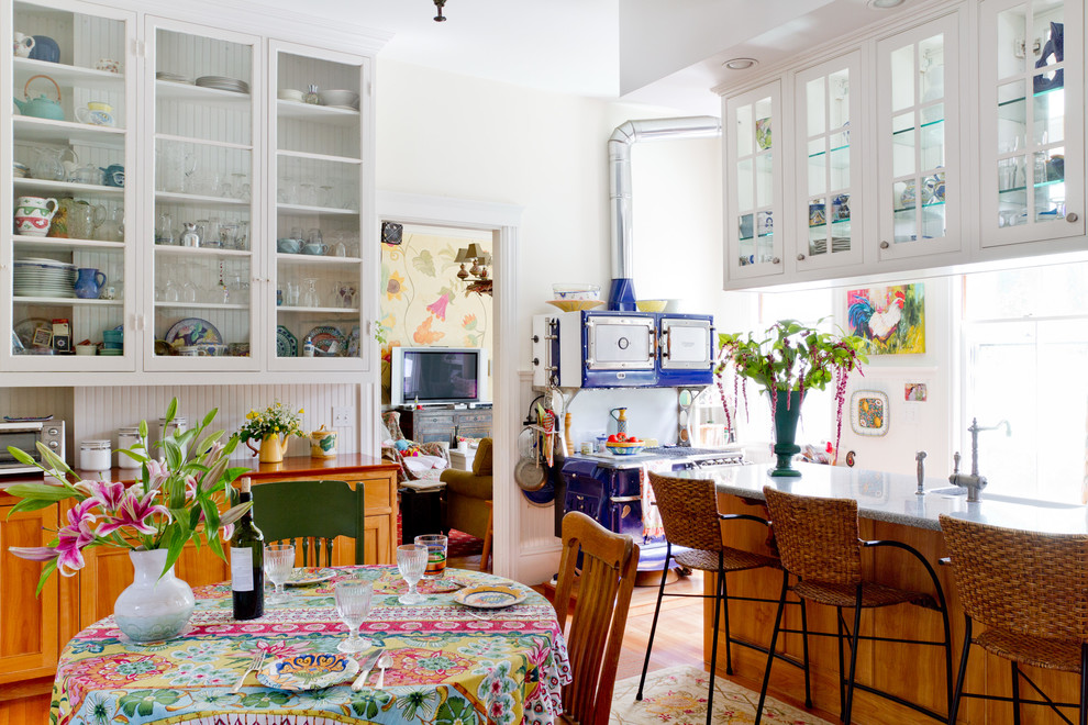Diseño de cocina comedor bohemia con armarios tipo vitrina, puertas de armario blancas y electrodomésticos de colores