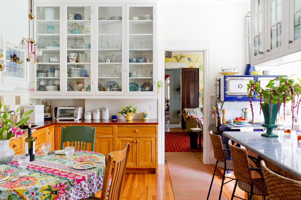 Example of an eclectic eat-in kitchen design in Boston with wood countertops, glass-front cabinets, white cabinets, multicolored backsplash and colored appliances