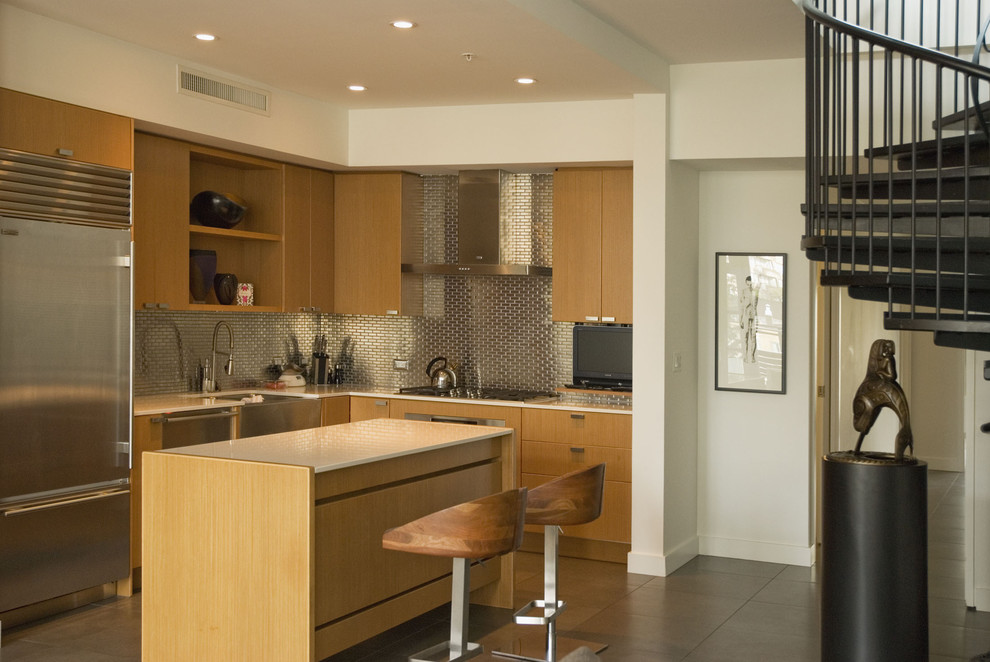 Cette image montre une cuisine design en L et bois brun avec un évier de ferme, un placard à porte plane, une crédence métallisée, une crédence en dalle métallique et un électroménager en acier inoxydable.