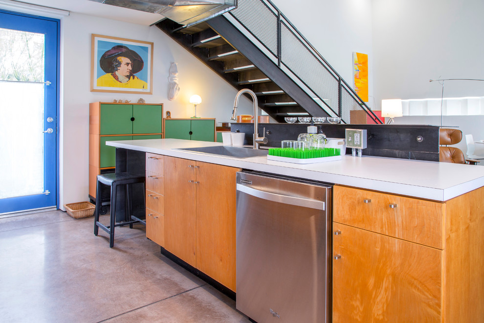 Cette photo montre une cuisine ouverte parallèle industrielle en bois brun avec un évier posé, un placard à porte plane, un électroménager en acier inoxydable, sol en béton ciré, îlot et un sol gris.