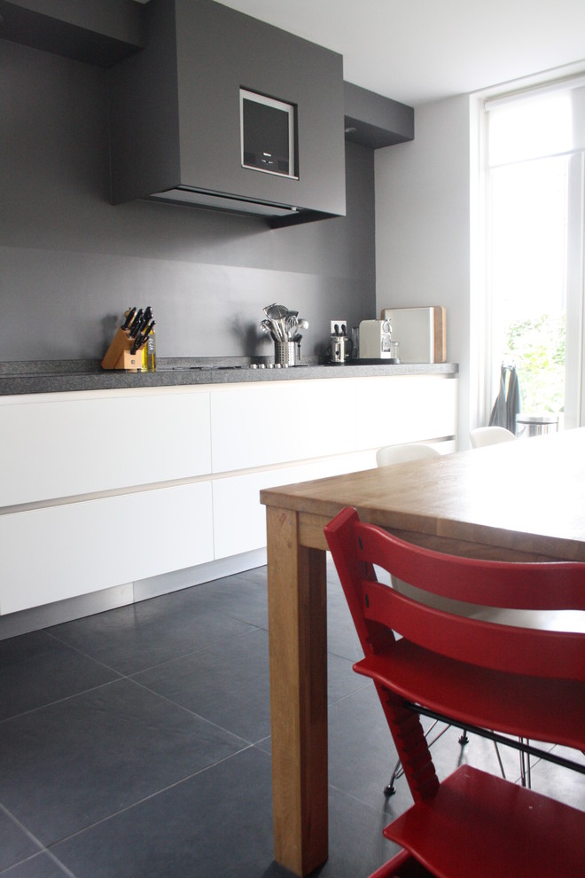 Moderne Küche mit Küchenrückwand in Grau, weißen Schränken und flächenbündigen Schrankfronten in Amsterdam