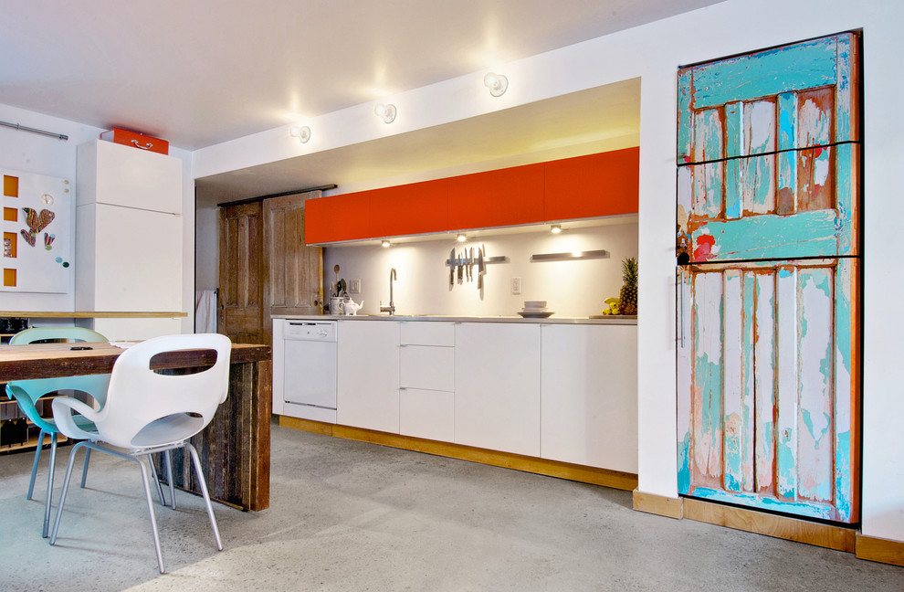 Idée de décoration pour une cuisine design avec un plan de travail en béton et un électroménager blanc.