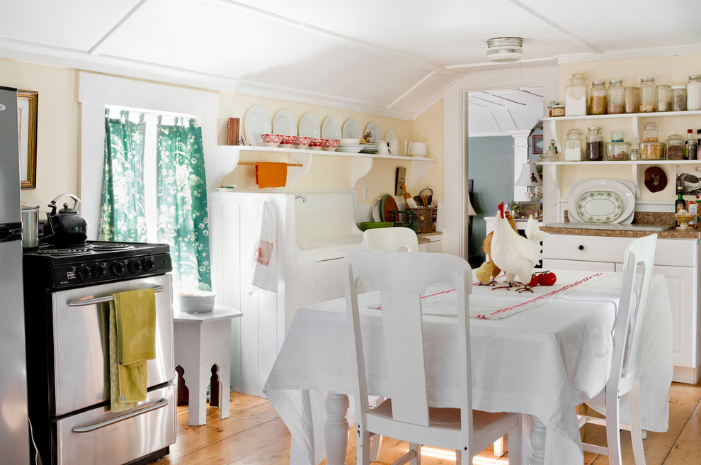 Foto på ett avskilt, litet eklektiskt kök, med öppna hyllor, vita skåp och ljust trägolv