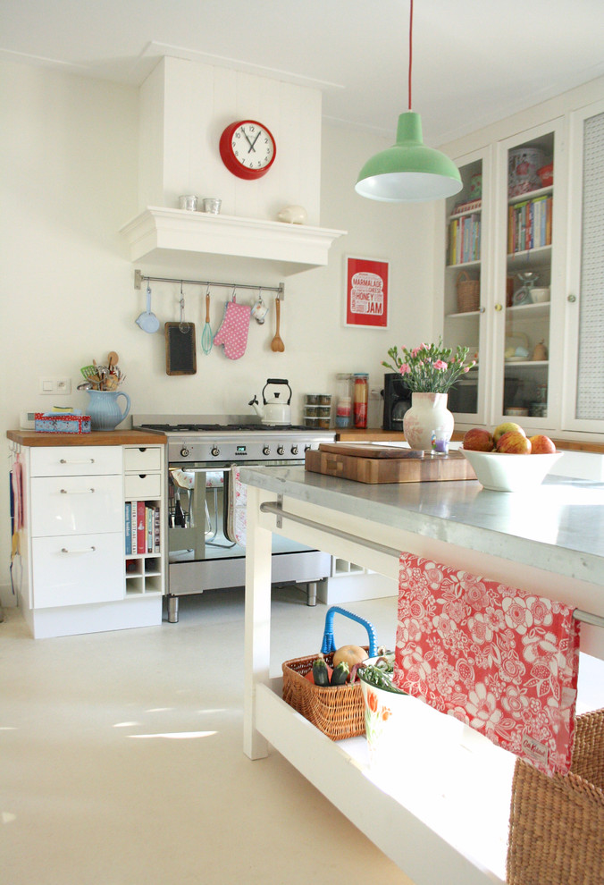 アムステルダムにあるコンテンポラリースタイルのおしゃれなキッチン (白いキャビネット、亜鉛製カウンター、シルバーの調理設備) の写真