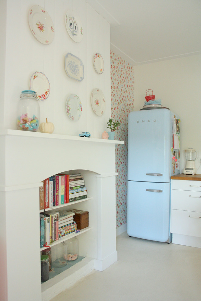 Ejemplo de cocina romántica con puertas de armario blancas, encimera de madera y electrodomésticos de colores