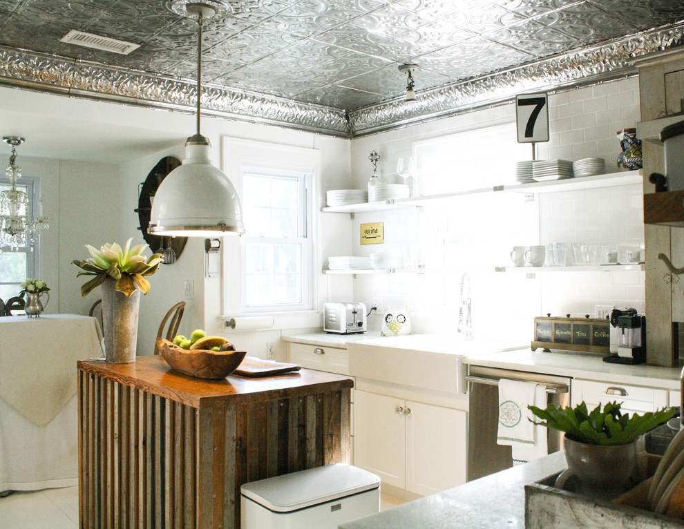 Eat-in kitchen - eclectic l-shaped eat-in kitchen idea in Tampa with a farmhouse sink, white backsplash, subway tile backsplash, stainless steel appliances and white cabinets