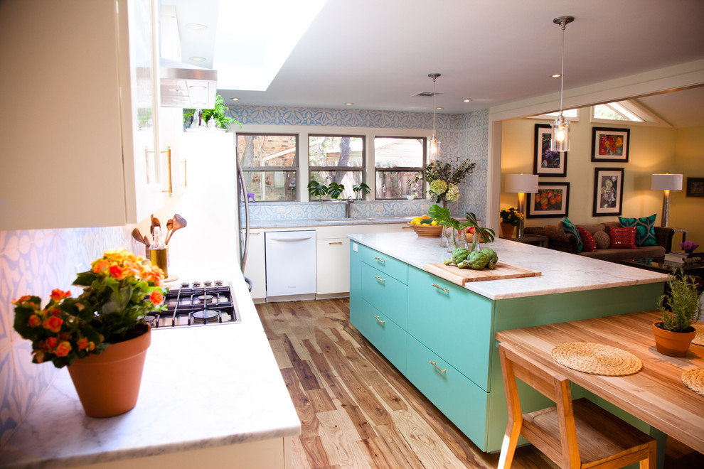 Bild på ett eklektiskt l-kök, med släta luckor, blå skåp, marmorbänkskiva och vita vitvaror