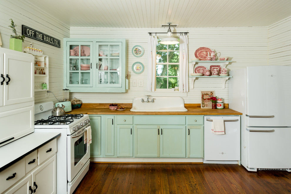 Foto på ett shabby chic-inspirerat brun l-kök, med en nedsänkt diskho, luckor med infälld panel, gröna skåp, träbänkskiva, vitt stänkskydd, stänkskydd i trä, vita vitvaror, mellanmörkt trägolv och brunt golv