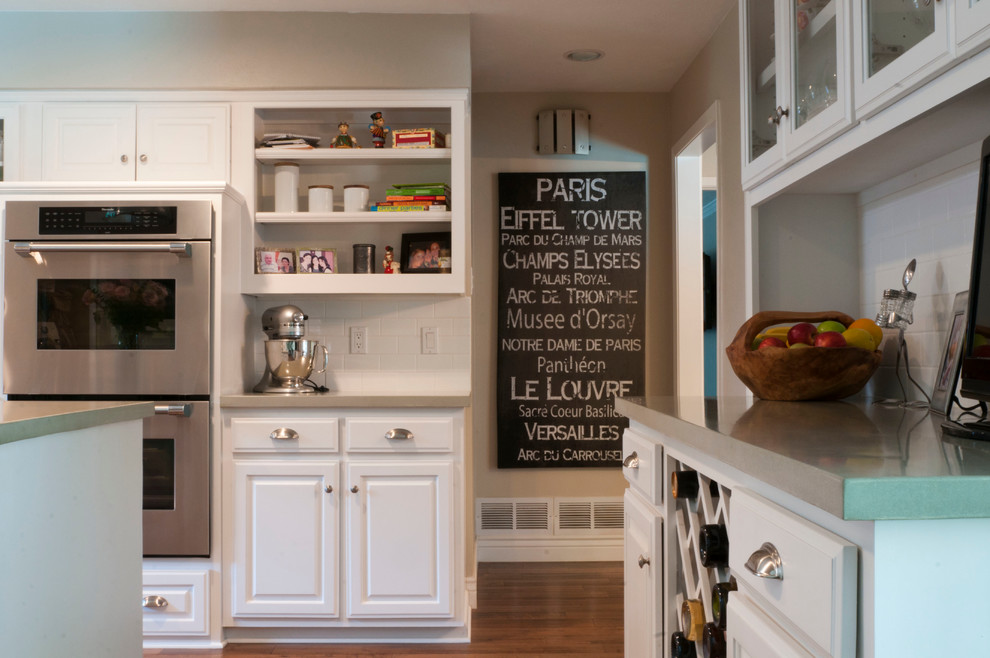 Klassische Küche mit profilierten Schrankfronten, weißen Schränken, Küchenrückwand in Weiß, Rückwand aus Metrofliesen und Küchengeräten aus Edelstahl in Dallas