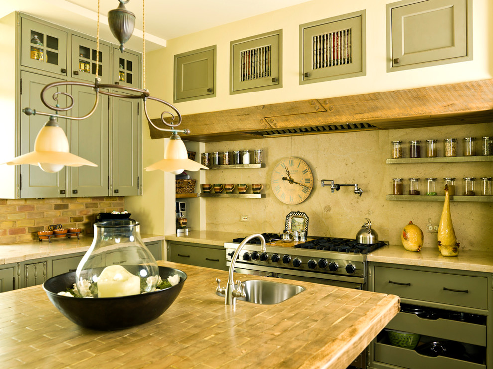 Свежая идея для дизайна: кухня в классическом стиле с деревянной столешницей, фасадами с утопленной филенкой, зелеными фасадами, техникой из нержавеющей стали, бежевым фартуком и фартуком из известняка - отличное фото интерьера