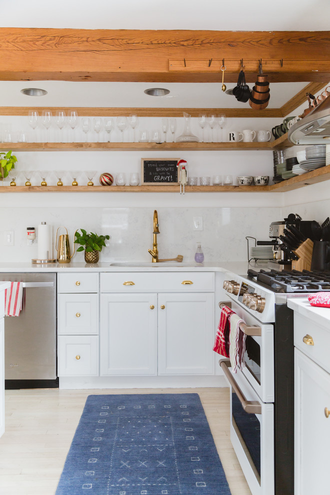 Modelo de cocinas en L escandinava con fregadero bajoencimera, armarios estilo shaker, puertas de armario blancas, salpicadero blanco, electrodomésticos de acero inoxidable, suelo beige y encimeras blancas