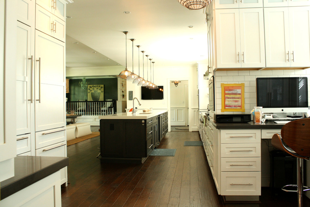 Exemple d'une cuisine parallèle chic avec un placard à porte shaker, des portes de placard blanches, une crédence blanche et une crédence en carrelage métro.