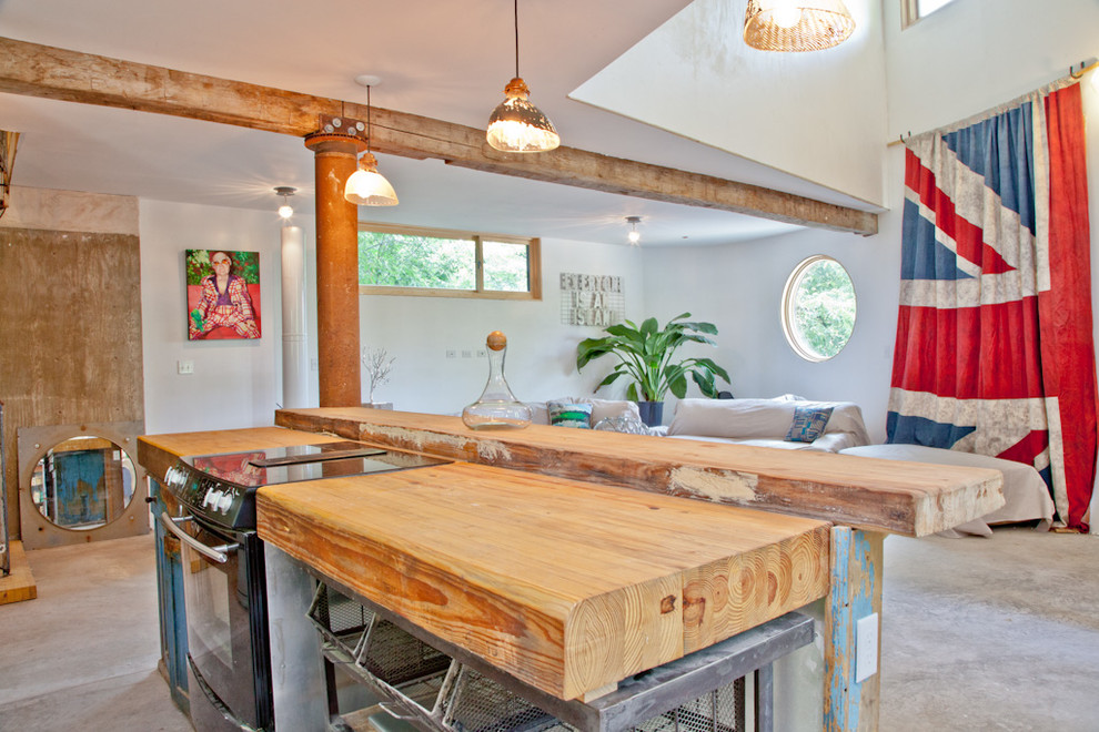 Inspiration for an eclectic kitchen remodel in Austin with wood countertops and black appliances