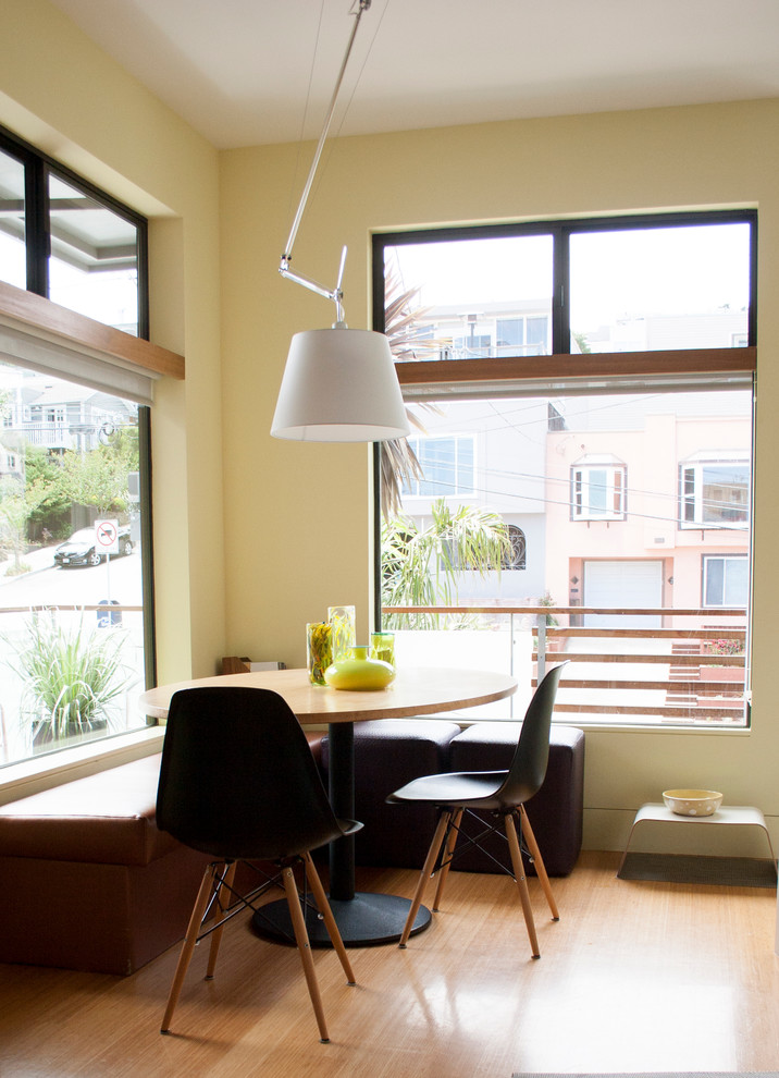 Immagine di una sala da pranzo aperta verso la cucina contemporanea con pareti beige e parquet chiaro