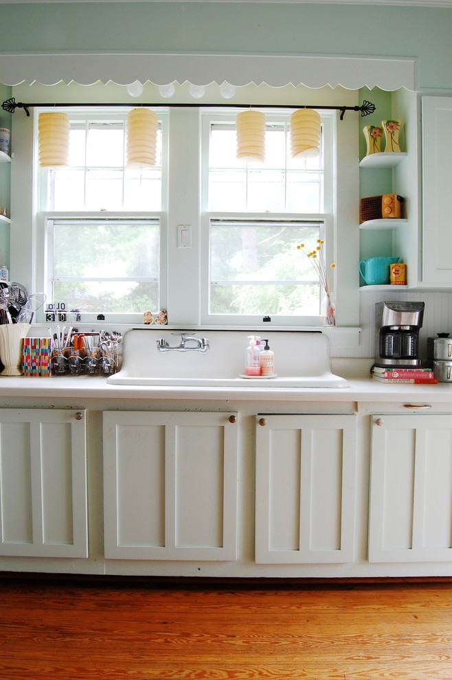Photo of an eclectic kitchen in New York with a built-in sink, shaker cabinets, white cabinets and white splashback.